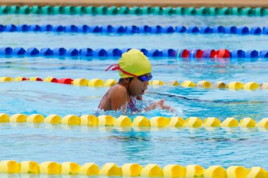 Yüzücü çocuk yüzme havuzunda kurbağalama yüzme stili yüzer. Su sporları ve yarışma, çocuklar için yüzme dersleri..