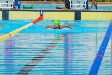 Yüzücü çocuk yüzme havuzunda kelebek yüzme stili yüzer. Su sporları ve yarışma, çocuklar için yüzme dersleri..