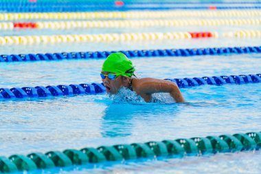 Yüzücü çocuk yüzme havuzunda kelebek yüzme stili yüzer. Su sporları ve yarışma, çocuklar için yüzme dersleri..
