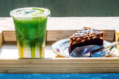 Çiçek desenli vintage tabak ve yeşil çay ile servis edilen bownie keki.