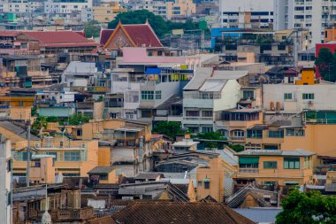 Bangkok, Tayland 'da kalabalık bir mahalle. Geleneksel düşük katlı evler uzak bir Tayland tapınağıyla harmanlanarak, bir çerçevede ruhanilik ve şehir hayatının karışımını yaratıyor.