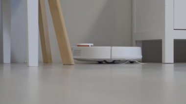 Robot elektrikli süpürge masanın etrafını temizler, akıllı sensörler. Yüksek kalite 4k görüntü