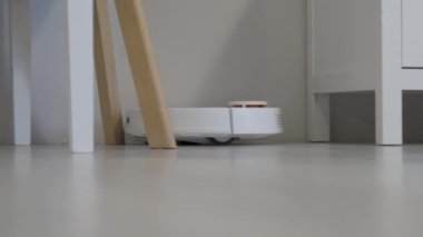 Robot elektrikli süpürge masanın etrafını temizler, akıllı sensörler. Yüksek kalite 4k görüntü