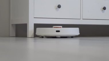 Robot elektrikli süpürge masanın etrafını temizler, akıllı sensörler. Yüksek kalite 4k görüntü