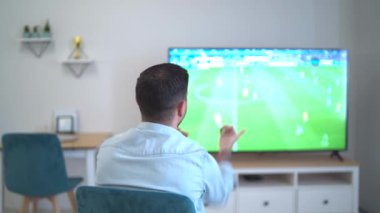 Futbol fanatiği evde, yazı tipi büyük TV ekranında. Yüksek kaliteli FullHD görüntüler