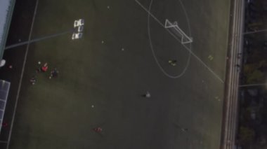 Şehrin iki blok arasındaki futbol stadyumunun dikey videosu. İnsanlar geceleri futbol oynuyorlar. Yüksek kalite 4k görüntü