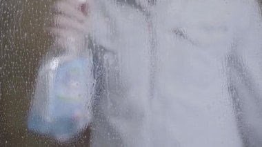 Pembe bir pencereyi silmek, bahar temizliği konsepti. Pencere Temizleme Servisi.