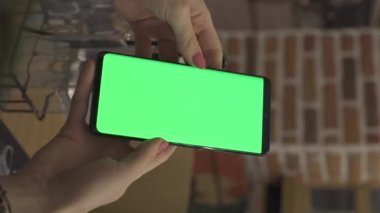 Akıllı telefon tutan kadın elleri, kapalı yeşil ekran kaydırma. Yeşil ekran akıllı telefon geçmişi olan bir kadın. Yüksek kaliteli FullHD görüntüler