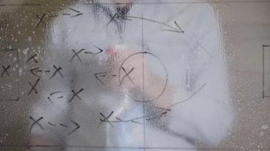 Futbol koçu, camlara siyah kalemle çizilmiş futbol taktikleri. Pembe bir pencereyi silmek, bahar temizliği konsepti. Pencere Temizleme Servisi. 