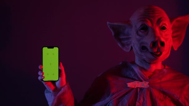 Τρομακτικός Άνθρωπος Μάσκα Χοίρων Κρατώντας Πράσινο Smartphone Οθόνη Ψυχοπαθής Άνθρωπος — Αρχείο Βίντεο