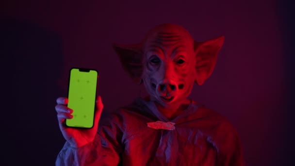 Enge Man Met Varkensmasker Met Groene Smartphone Psychopaat Man Cape — Stockvideo