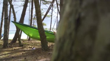 Kamuflaj tatili, ağaçların ve çadırların yanında kitap okumak. Yüksek kaliteli FullHD görüntüler