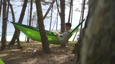 relaxing holiday touristenjoy holiday reading in near trees. High quality FullHD footage