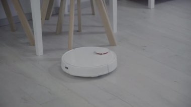 Robot vacuum cleaner with lidar navigation clean around chair. High quality 4k footage