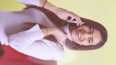 Vertical video of beautiful smiling girl talking and while holding shopping bags over her shoulder. High quality FullHD footage