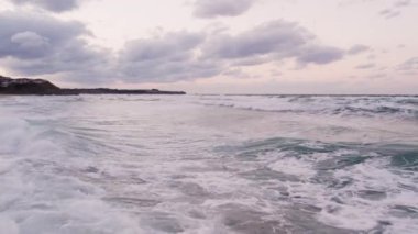 drone flying low at water surface against top sunset clouds. High quality 4k footage