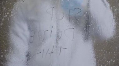 young man cleans windows with spray at home. High quality 4k footage