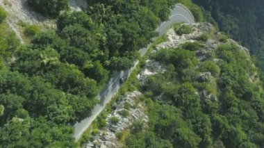 cinematic vertical video of car driving up a winding road through the Beklemeto in Bulgaria during the colorful spring season. High quality FullHD footage
