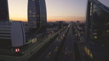 Sofias 'ın kalabalık iş bölgesinde trafik yoğunluğunun panoramik görüntüsü, arabalar ve otobüsler işlek caddelerde zikzak çizerken. Modern ofis binalarının yüksek cam cepheleri...