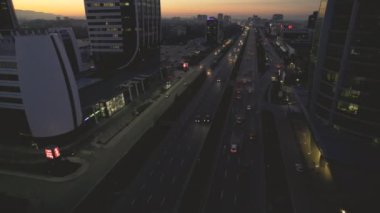 Sofias iş bölgesinin göbeğindeki hareketli trafiğin havadan görünüşü, arka planda dik duran modern yüksek katlı ofis binaları. Şehir silueti siluetlerle kaplanmış.
