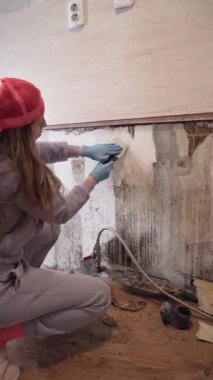 Bu dikey DIY ev onarım videosundaki eski duvar kağıtlarını kaldırarak kendini işine adamış bir kadını izleyin. Yenileme dersleri, iç tasarım projeleri ve ev geliştirme için mükemmel.
