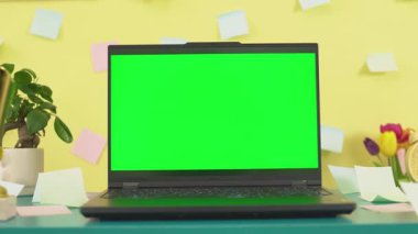 Boş yeşil ekranlı dizüstü bilgisayar. Sarı ofis arka planı, 4K 30fps. Yüksek kalite 4k görüntü