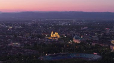 Gün batımından hemen sonra Sofya 'nın havadan görünüşü alacakaranlıkta parlamaya başlayan yeşil bir parkı ve binaları gösteriyor.