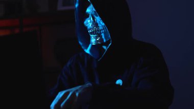 Kapüşonlu kapüşonlu ve maskeli tiplerin arkasına saklanmış bir siber saldırgan. Görüntü konsepti çevrimiçi tehditleri, sistem hacklemeyi ve siber savaş risklerini kapsıyor.