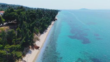 İnsansız hava aracı görüntüleri Halkidiki 'nin Neos Marmaras ve Nikiti yakınlarındaki çarpıcı sahil şeridini gösteriyor. Kristal berraklığında turkuaz sular, yemyeşil tepeler, kumlu plajlar ve huzurlu bir Akdeniz atmosferi