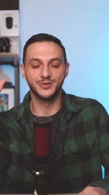 Mobil Platformlar için Dikey Çerçeve Kullanarak Evde Solo Podcast Episode kaydederken Mikrofona Konuşan Adam. Yüksek kaliteli FullHD görüntüler