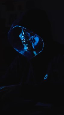 Bir dizüstü bilgisayardaki karanlık web içeriğinde gezinen gölgeli bir figür. Siber casusluk, yasadışı operasyonlar veya yeraltı web aktiviteleri için kavramsal sahne.