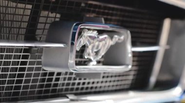 Ford Mustang emblem on a classic car. Symbolizes speed, performance, and the legacy of American muscle cars.
