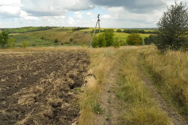 Sonbaharın başlarında tarla ve toprak yol sürülmüş. Muhteşem manzaralar, Ukrayna tepeleri