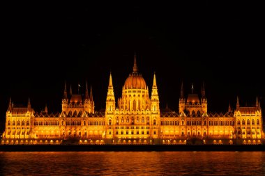 This breathtaking photograph captures the nighttime splendor of the Orszaghaz, the iconic Parliament Building of Budapest, as it stands magnificently illuminated along the Danube River. The image clipart