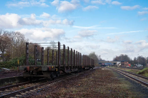 Empty railway freight wagons on the railway track. Road bridge in the background.