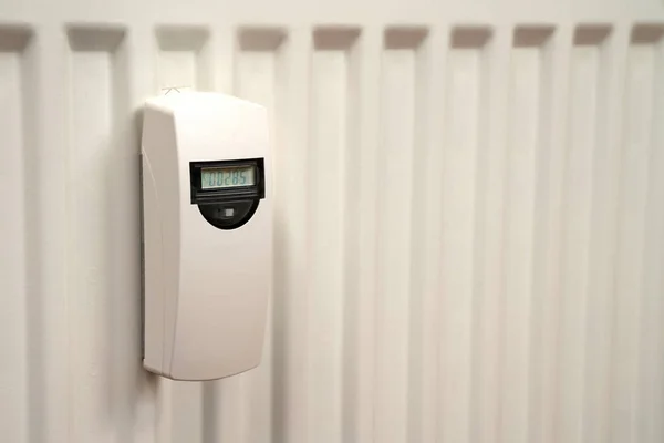 Heat consumption meter on the white radiator. Close up.