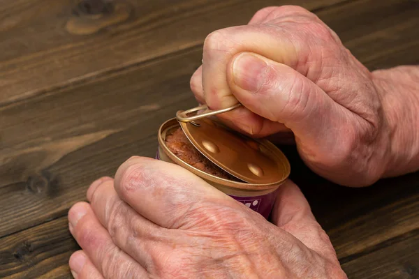 stock image Hands of an elderly man opening a aluminium tin can. Close up.