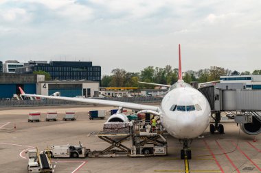 Bagajları yüklerken havaalanında bir uçak. Ön görünüm.