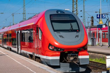 Turuncu tren vagonu boş bir platformda duruyor. Ön görünüm.