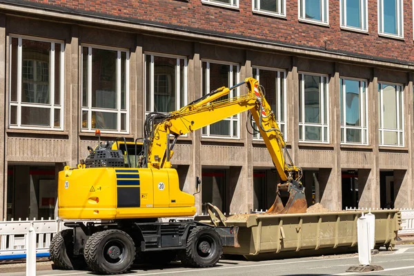 Escavadora Amarela Brilhante Fundo Edifício Cidade Balde Repousa Sobre Recipiente — Fotografia de Stock