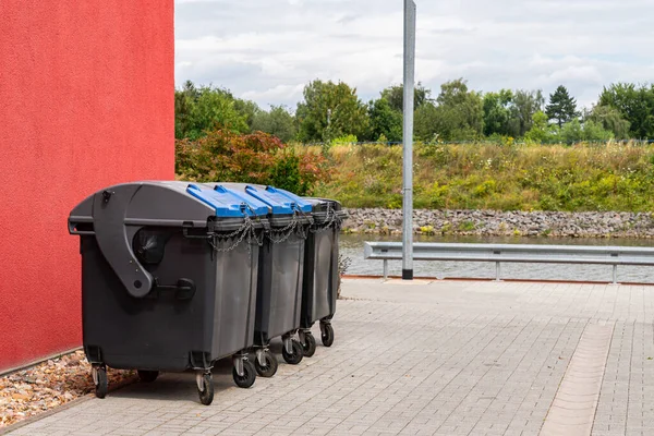 Black Plastic Trash Cans Closed Chain Stand Large Red Building — Stock Photo, Image