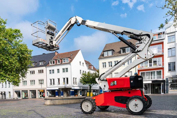 Şehrin yaya kesimindeki insanlar için hidrolik kaldırma platformu. Mavi gökyüzü ve ışık bulutları.