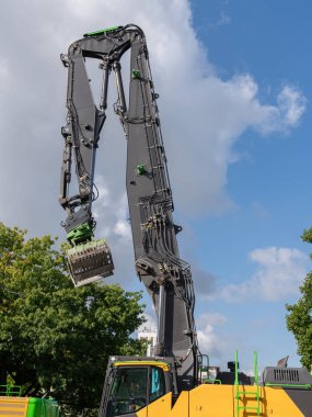 Gri kazıcı beyaz bulutlu mavi gökyüzünün arka planında patladı