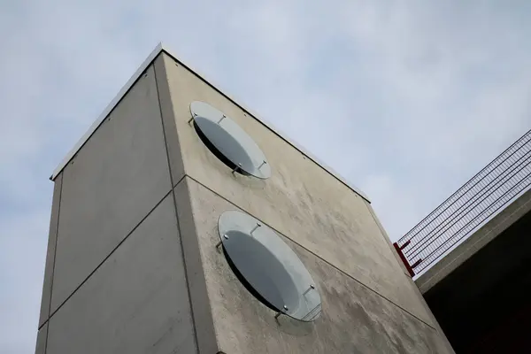 The walls of a concrete rectangular building with round windows. Bottom view.