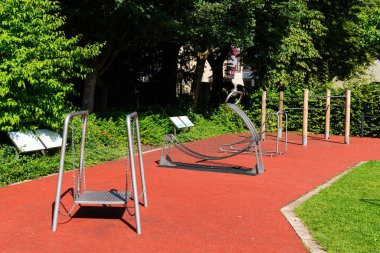 Şehir parkında çeşitli spor malzemelerinin bulunduğu bir spor sahası..