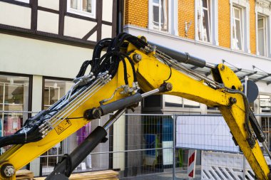 Sarı kazıcının hidrolik kısmı şehir binalarının arka planına karşı..