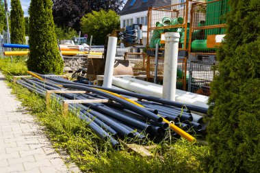 Üzerinde farklı renkte su boruları ve plastik lağım boruları olan inşaat alanı..