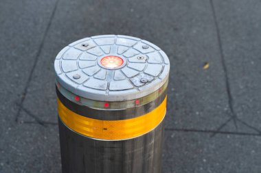 Sarı şeritli ve kırmızı ışıklı geri çekilebilir bir boğa alçak konumda, araçların geçmesine izin veriyor..