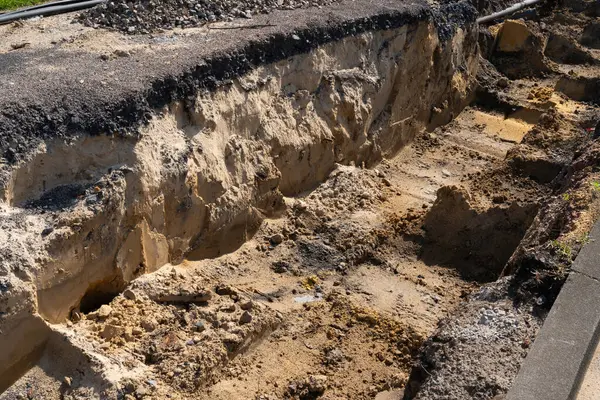 Yolun kenarında büyük bir çukur kazıldı. Toprak siperin iki tarafına da istiflendi..