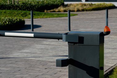 Manikürlü çimenler ve asfalt yollarla çevrili çağdaş bir açık hava alanının girişinde bir bariyer kapısı duruyor. Gündüz vakti iyi korunan bir ortamda konumlandırılmıştır..